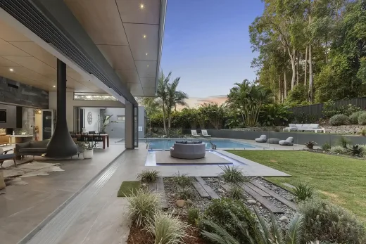Modern home with a covered patio, hanging fireplace, pool and gravel beds